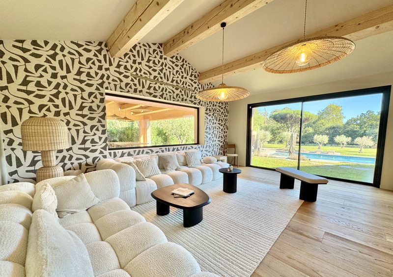 Salon lumineux avec baie vitrée sur la piscine