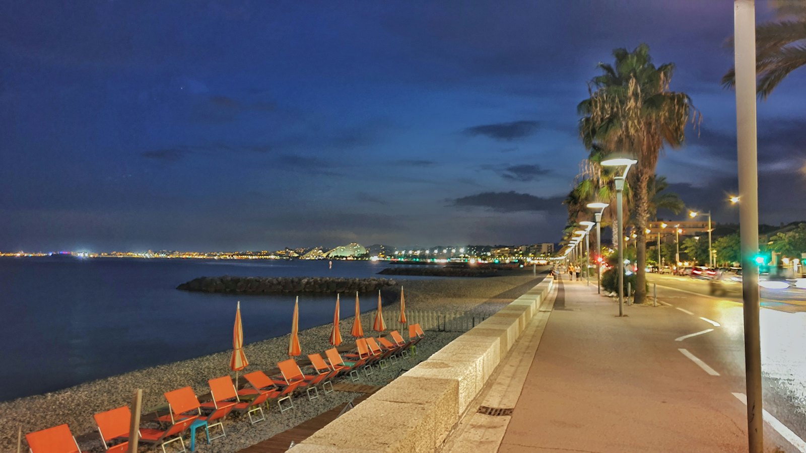 Le front de mer de Cagnes-sur-Mer à la tombée de la nuit, avec ses palmiers et ses transats
